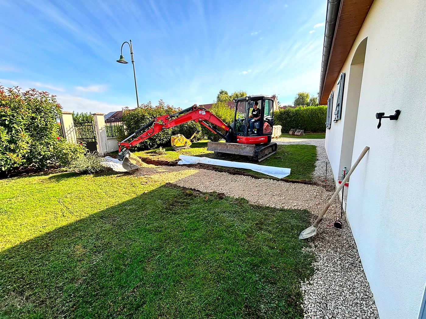 Mini-pelle en terrassement dans un jardin